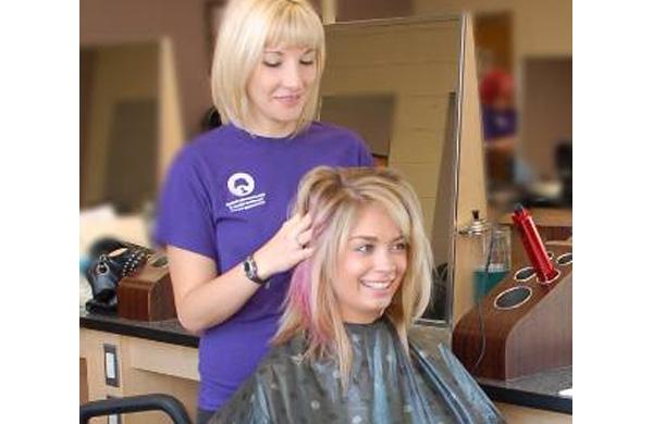 Student getting finishing touches to hair styled at Transitions School of Cosmetology